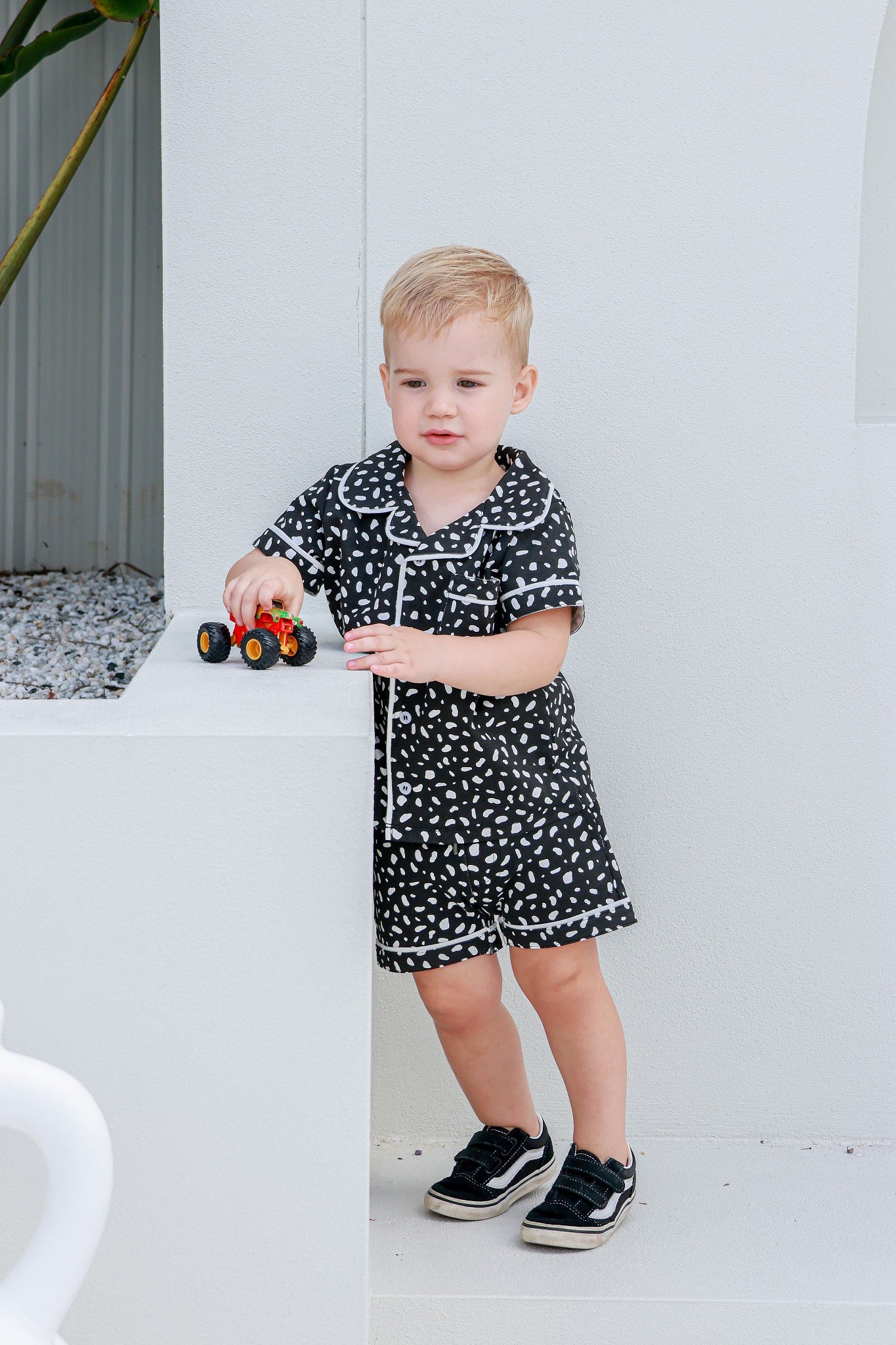 Boy wearing a black and white piped pajama set, combining classic style with cozy comfort.