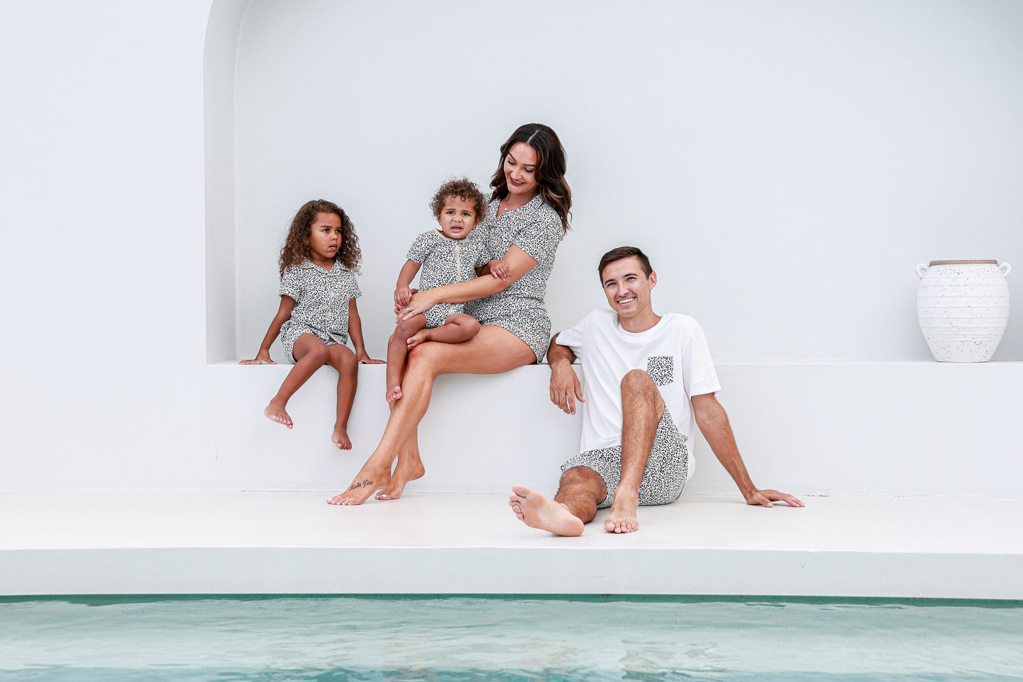 Family wearing matching leopard print pajamas, enjoying a fun and cozy moment together.