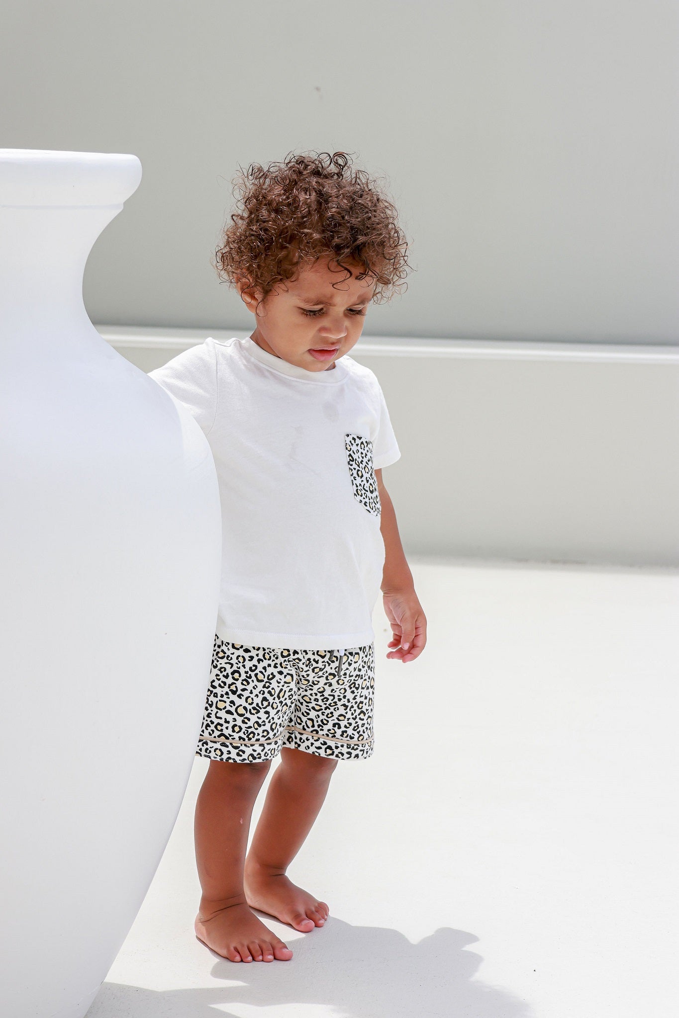 Kid walking and wearing a leopard print pocket tee, adding a fun and trendy touch to their casual style