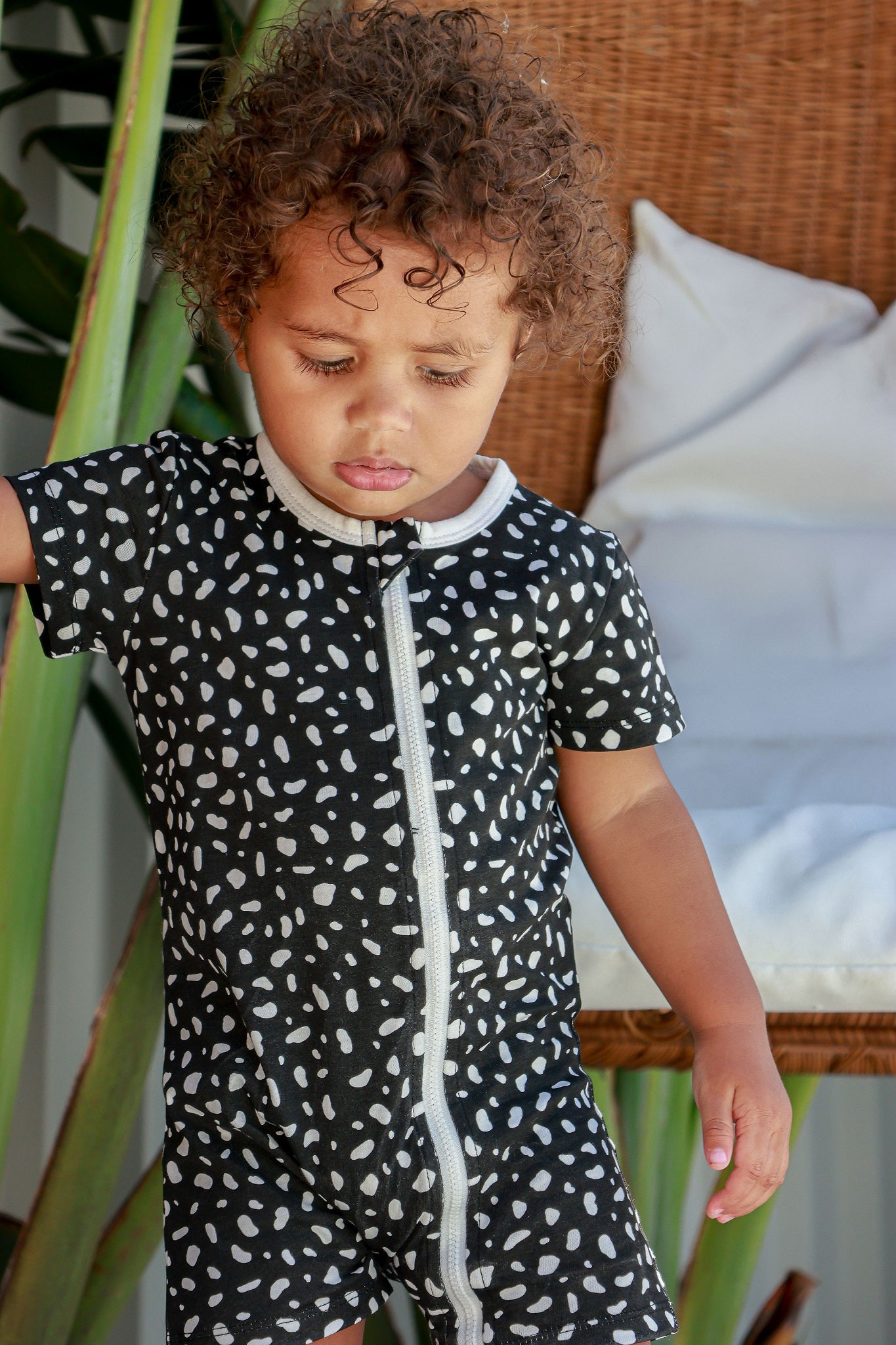 toddler boy wearing white and black spotted romper