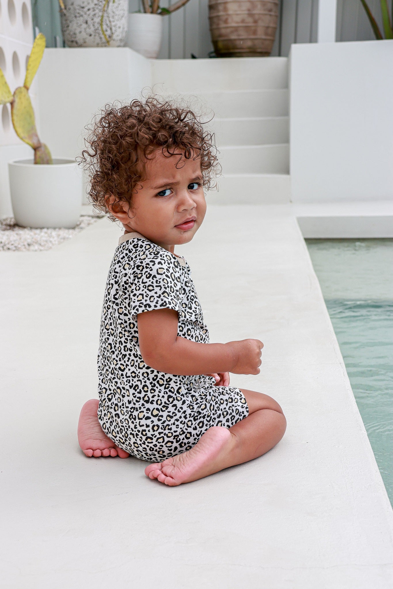toddler boy sitting wearing leopard print romper pyjamas