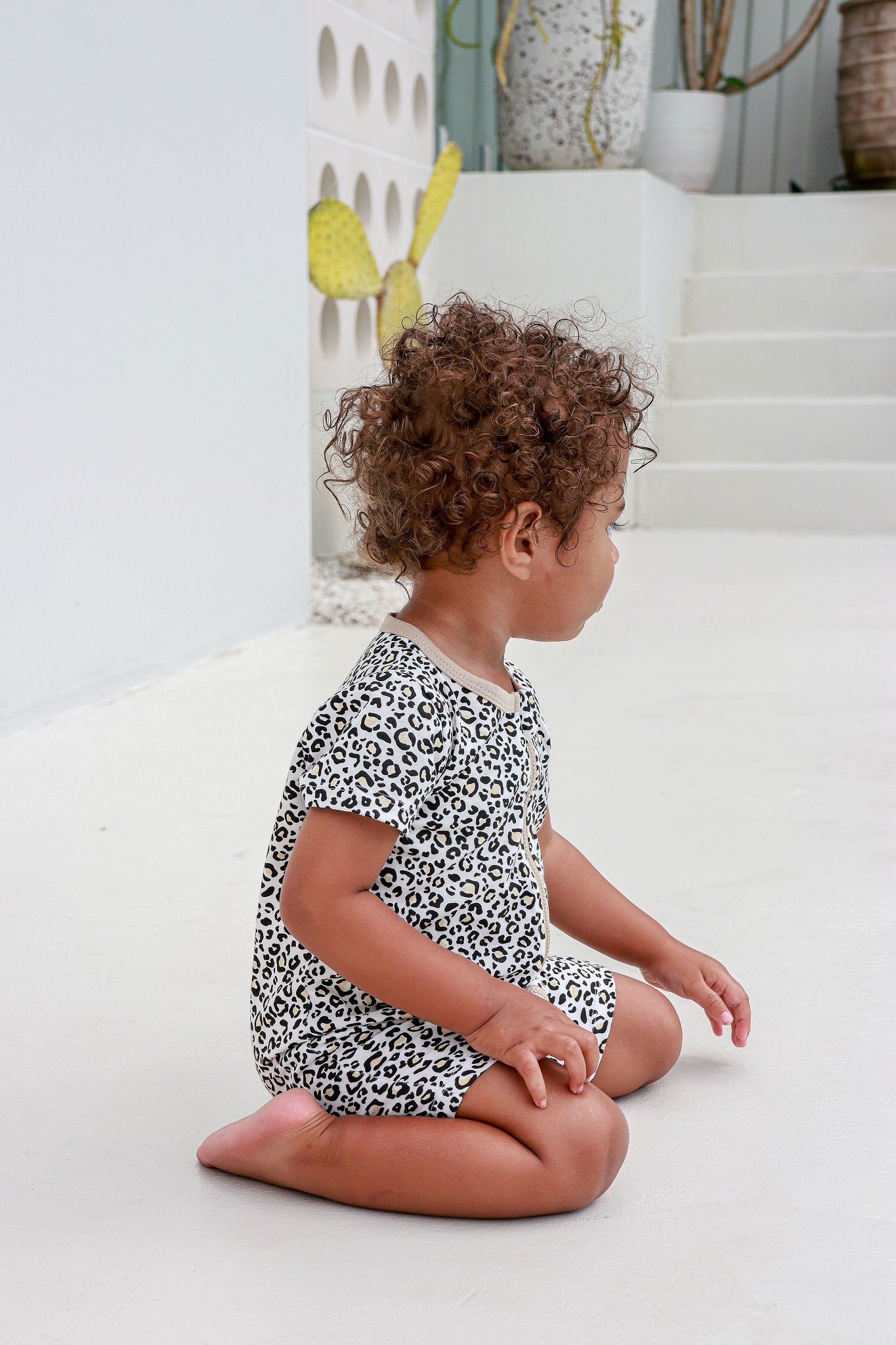 toddler boy sitting wearing leopard print romper pyjamas