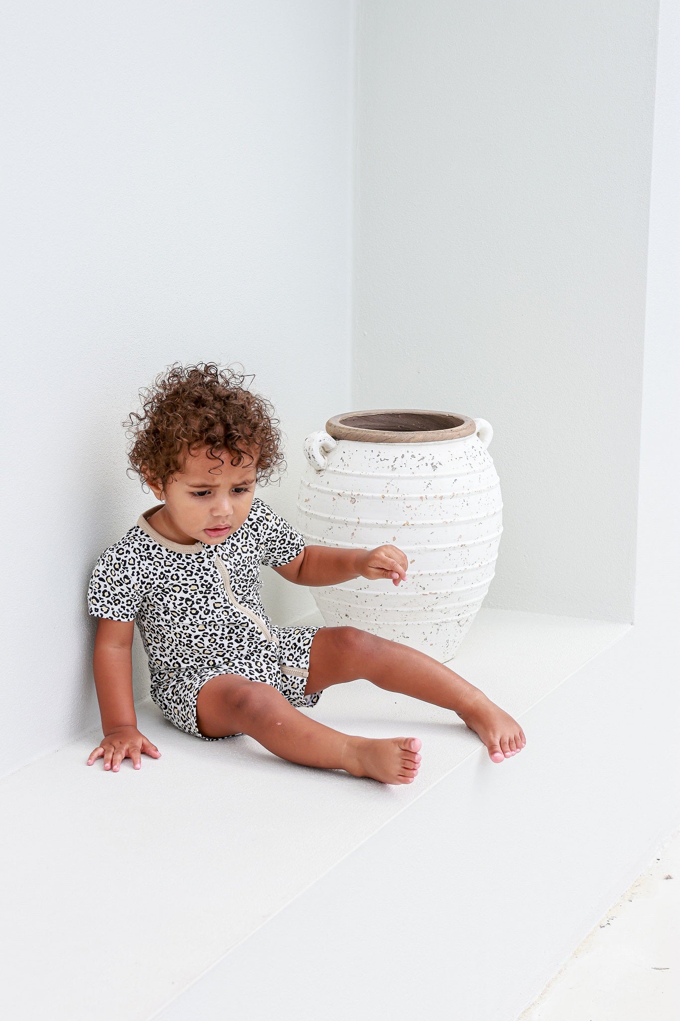 toddler boy sitting wearing leopard print romper pyjamas