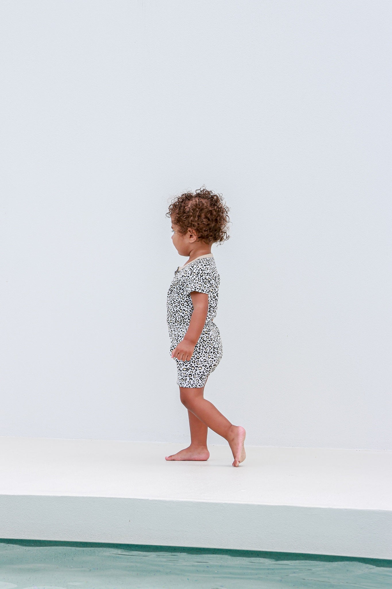 toddler boy standing wearing leopard print romper pyjamas