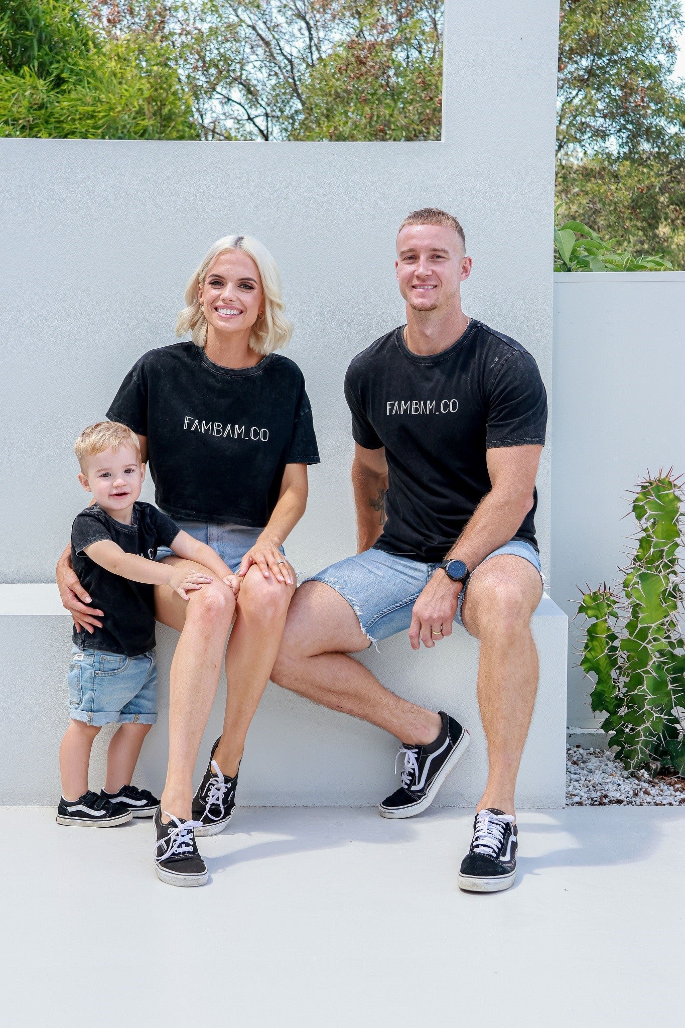 Family laughing and smiling while wearing matching acid wash shirts
