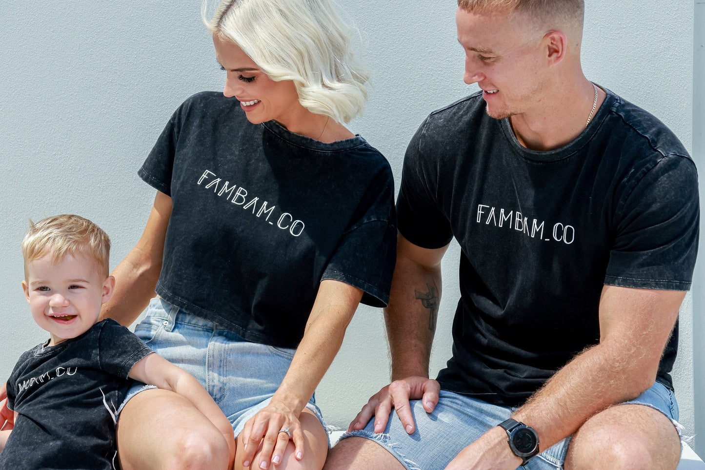 Family laughing and smiling while wearing matching acid wash shirts