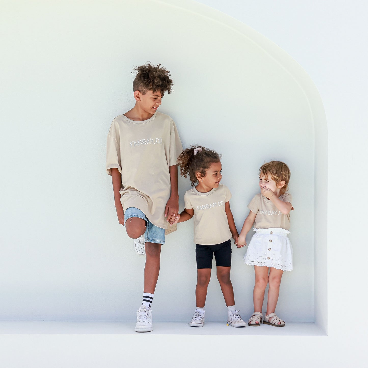 kids wearing matching shirts on white backdrop step