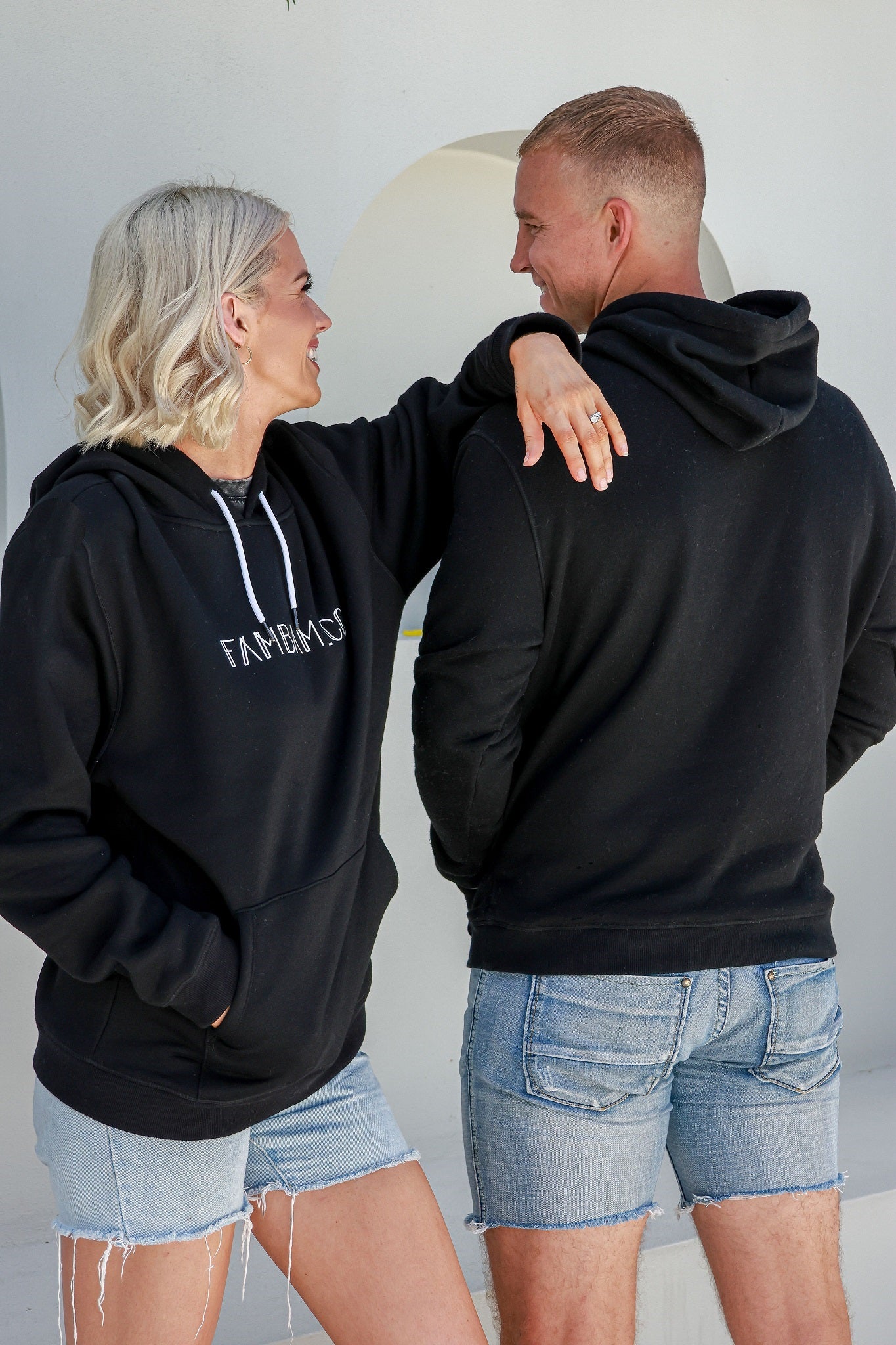 woman and man standing together wearing black matching hoodies