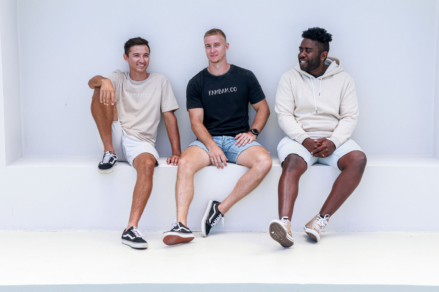 Three guys sitting together wearing logo apparel