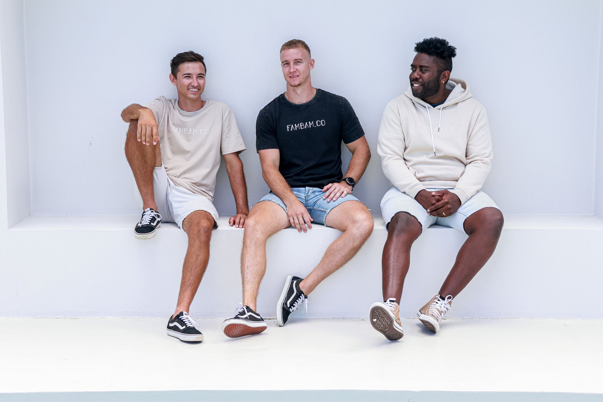 Three guys sitting together wearing logo apparel