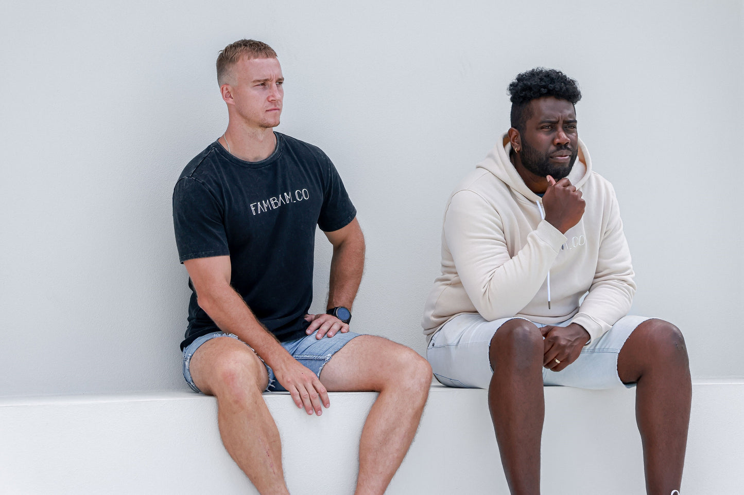 two men sitting together wearing logo apparel