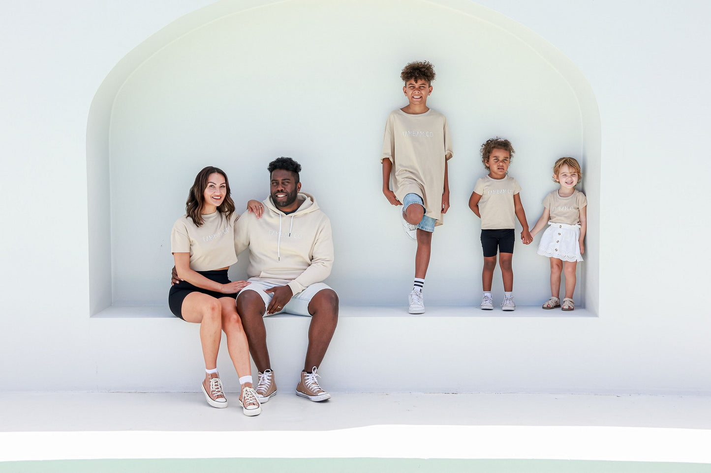 family wearing matching shirts on white backdrop step