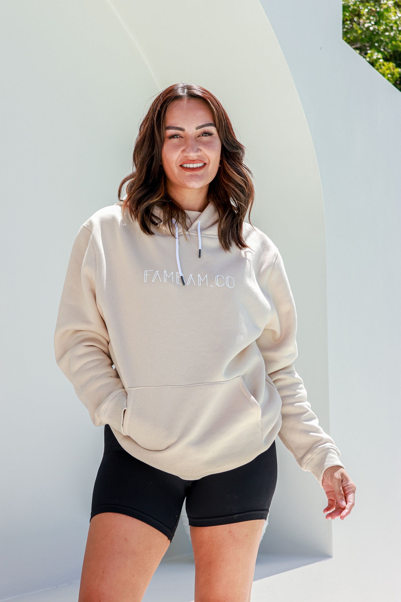 woman standing in beige hoodie jumpers smiling