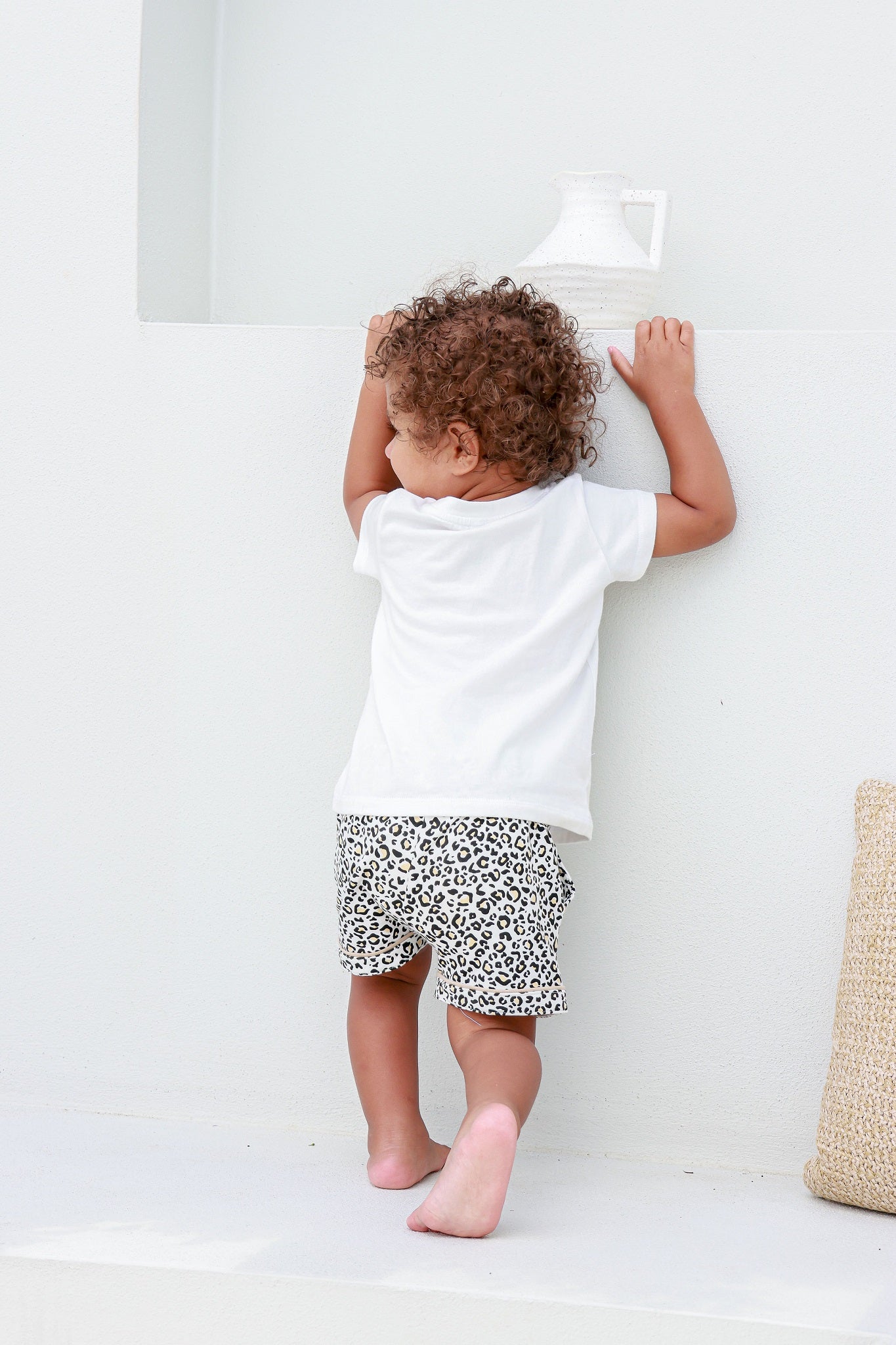 Kid climbing while wearing a leopard print pocket tee, combining fun and stylish comfort.