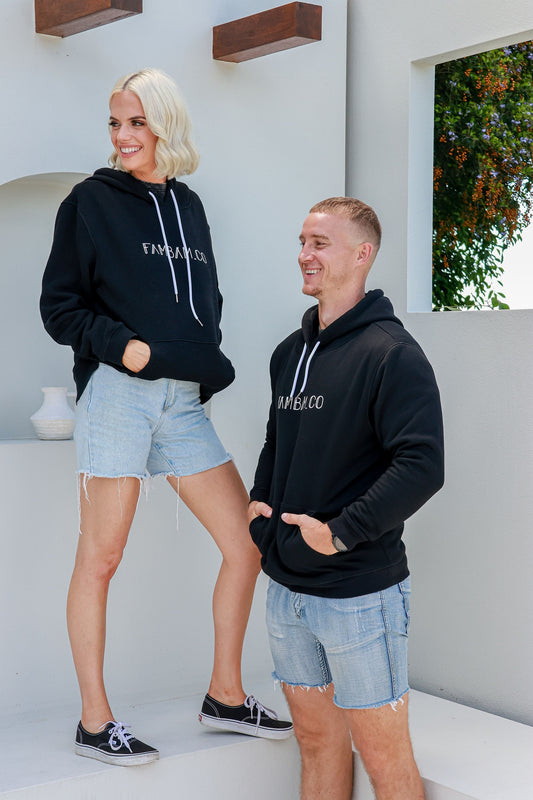 couple standing together on white step wearing matching hoodies jumpers