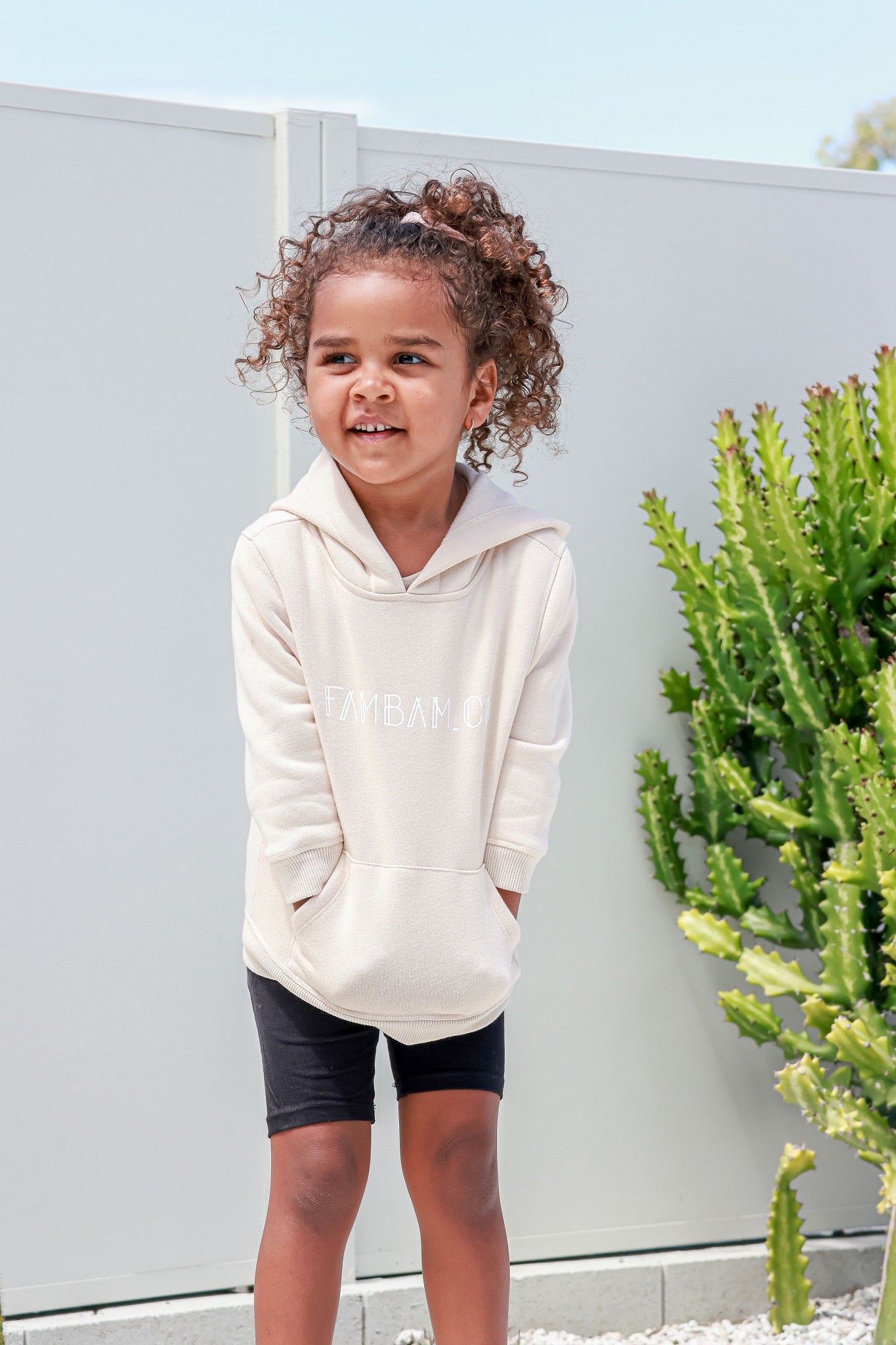 girl wearing jumper hoodie in beige smiling 
