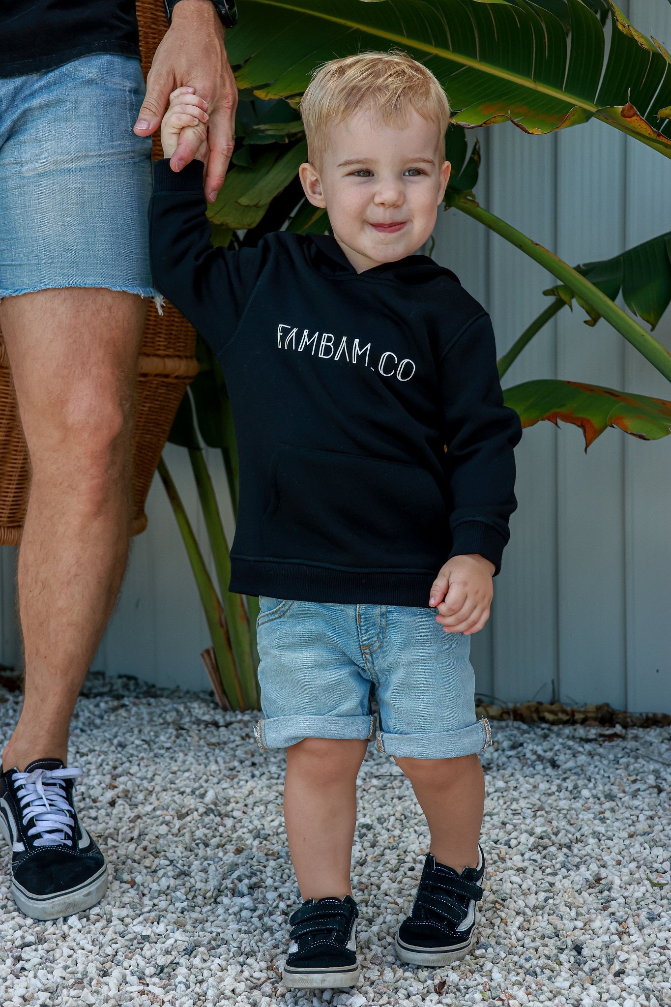 toddler boy holding hands with dad wearing black jumper