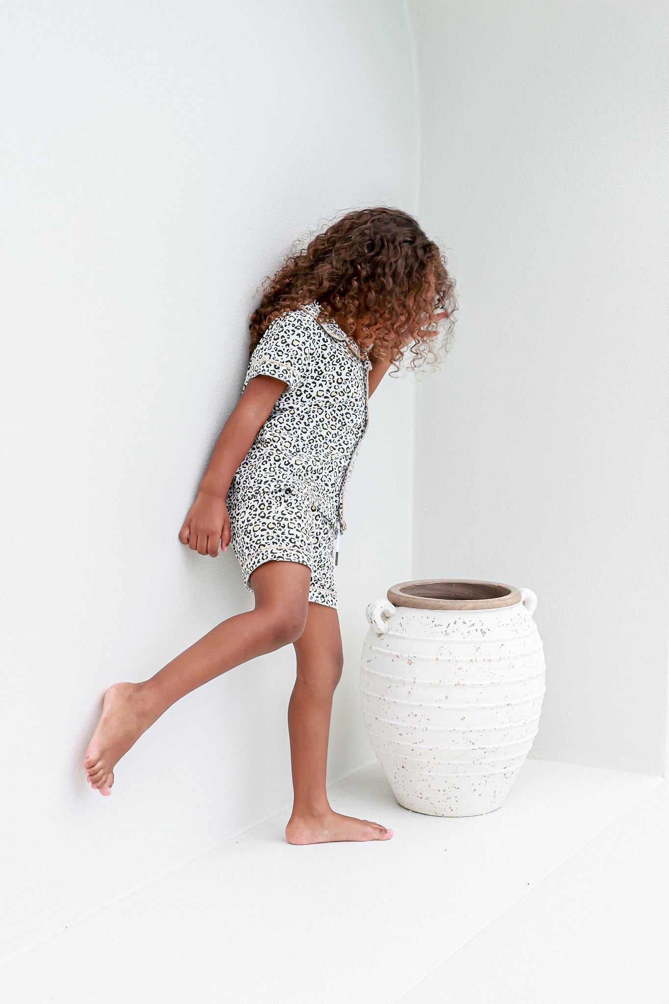Toddler girl looking into vase wearing leopard print pyjama sets pj's pajamas