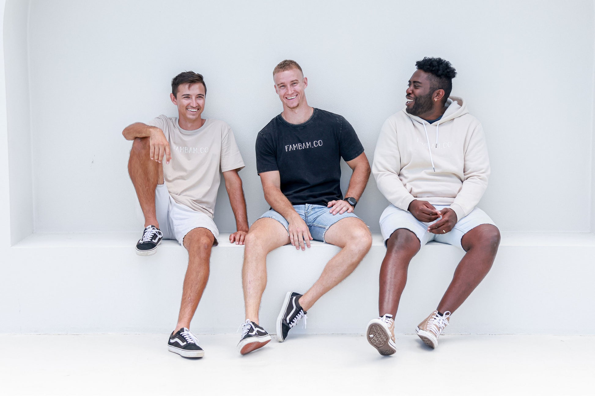 three men sitting together in matching logo apparel 