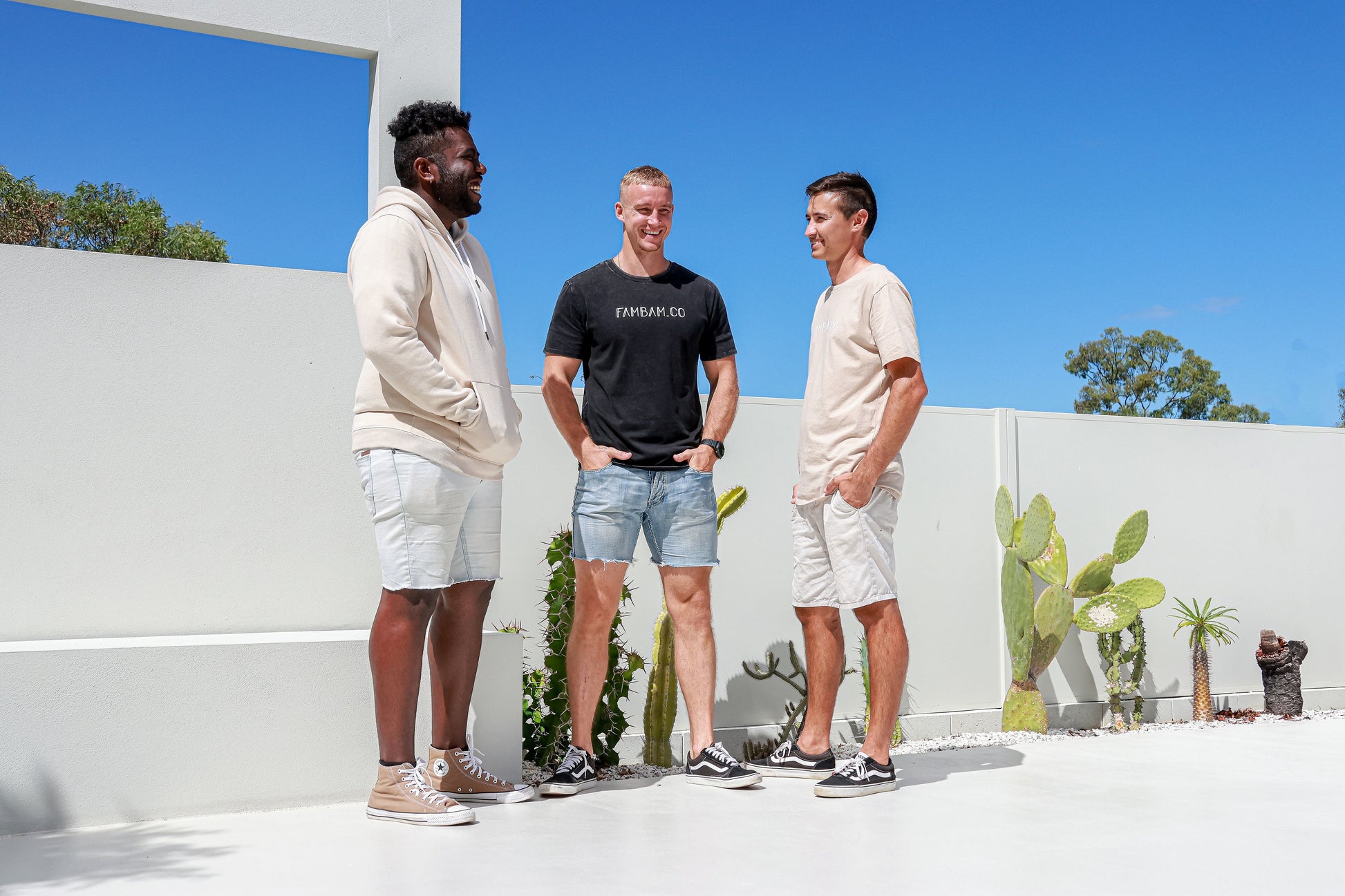 three men standing together in matching logo apparel 