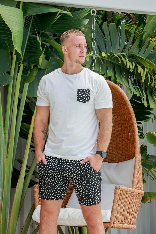 Man standing outside in front of a egg chair in white and black spotted pyjamas pjs pajamas